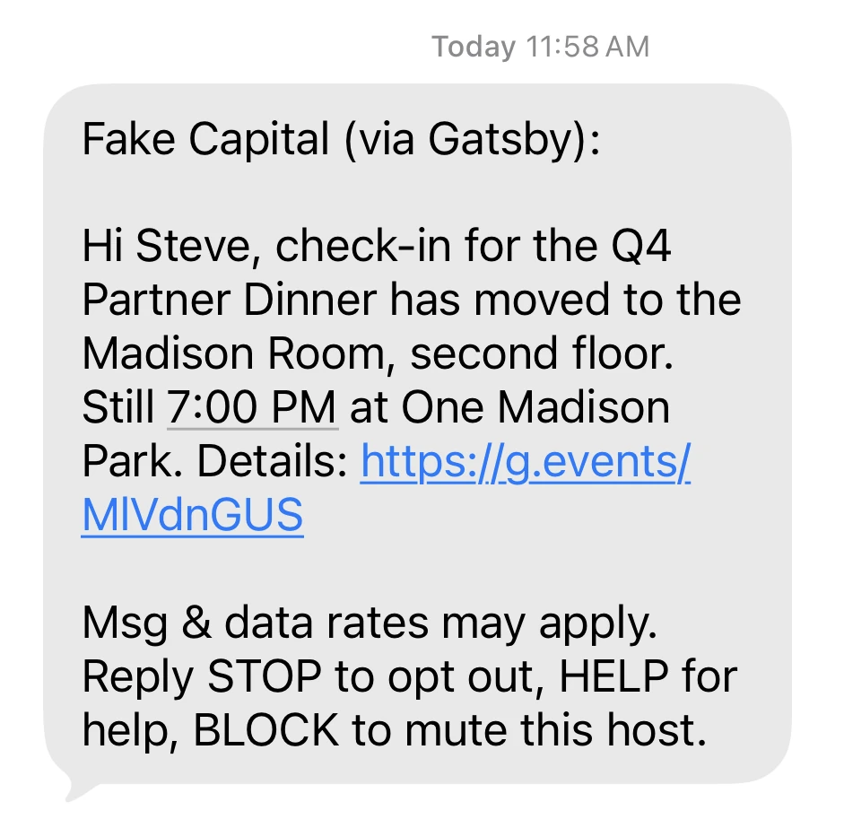 A text message on a phone. It reads Fake Capital (via Gatsby), then Hi Steve, check-in for the Q4 Partner Dinner has moved to the Madison Room, second floor. Still 7:00 PM at One Madison Park. Details, followed by a g.events link. The last lines read Msg & data rates may apply. Reply STOP to opt out, HELP for help, BLOCK to mute this host.